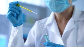 Εργαζόμενος εργαστηρίων που στάζει το κίτρινο υγρό στο σωλήνα δοκιμής, ποιοτικός έλεγχος πετρελαίου, πείραμα στοκ εικόνα με δικαίωμα ελεύθερης χρήσης Εργαζόμενος εργαστηρίων που στάζει το κίτρινο υγρό στο σωλήνα δοκιμής, ποιοτικός έλεγχος πετρελαίου, πείραμα στοκ εικόνα με δικαίωμα ελεύθερης χρήσης