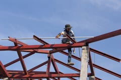 Εργαζόμενος που εγκαθιστά τη δομή του χάλυβα στεγών για το καινούργιο σπίτι στο const Στοκ Εικόνες Εργαζόμενος που εγκαθιστά τη δομή του χάλυβα στεγών για το καινούργιο σπίτι στο const Στοκ Εικόνες