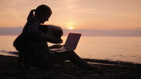 Εργασίες γυναικών blogger με ένα lap-top, αυτή που αποσπάται το κουτάβι της απόθεμα βίντεο Εργασίες γυναικών blogger με ένα lap-top, αυτή που αποσπάται το κουτάβι της απόθεμα βίντεο