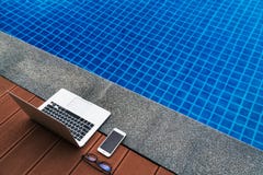 Εργασιακός χώρος στο θέρετρο Γυαλιά lap-top και smartphone κοντά στην μπλε πισίνα συσκευές σύγχρονες στοκ εικόνες με δικαίωμα ελεύθερης χρήσης Εργασιακός χώρος στο θέρετρο Γυαλιά lap-top και smartphone κοντά στην μπλε πισίνα συσκευές σύγχρονες στοκ εικόνες με δικαίωμα ελεύθερης χρήσης