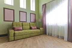 Εσωτερικό στα πράσινα και ρόδινα χρώματα με τον πράσινο καναπέ και το ελαφρύ παρκέ στοκ εικόνες Εσωτερικό στα πράσινα και ρόδινα χρώματα με τον πράσινο καναπέ και το ελαφρύ παρκέ στοκ εικόνες