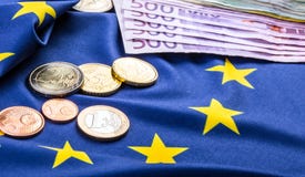 Ευρωπαϊκή σημαία και ευρο- χρήματα Ευρωπαϊκό νόμισμα νομισμάτων και τραπεζογραμματίων που τοποθετούνται ελεύθερα στην ΕΥΡ στοκ εικόνα Ευρωπαϊκή σημαία και ευρο- χρήματα Ευρωπαϊκό νόμισμα νομισμάτων και τραπεζογραμματίων που τοποθετούνται ελεύθερα στην ΕΥΡ στοκ εικόνα