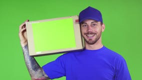 Ευτυχές deliveryman κουτί από χαρτόνι τοποθέτησης χαμόγελου με το copyspace στον ώμο του απόθεμα βίντεο Ευτυχές deliveryman κουτί από χαρτόνι τοποθέτησης χαμόγελου με το copyspace στον ώμο του απόθεμα βίντεο
