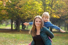Ευτυχές mom με ένα χαμόγελο που παίζει με την κόρη της στο πάρκο μια θερινή ημέρα στοκ εικόνα με δικαίωμα ελεύθερης χρήσης Ευτυχές mom με ένα χαμόγελο που παίζει με την κόρη της στο πάρκο μια θερινή ημέρα στοκ εικόνα με δικαίωμα ελεύθερης χρήσης
