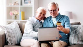 Ευτυχές ανώτερο ζεύγος με το lap-top και την πιστωτική κάρτα απόθεμα βίντεο Ευτυχές ανώτερο ζεύγος με το lap-top και την πιστωτική κάρτα απόθεμα βίντεο