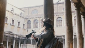Ευτυχές επαγγελματικό θηλυκό blogger με τη κάμερα που παίρνει τη φωτογραφία, που περπατά επάνω στο αρχαίο κτήριο με τους στυλοβάτ απόθεμα βίντεο Ευτυχές επαγγελματικό θηλυκό blogger με τη κάμερα που παίρνει τη φωτογραφία, που περπατά επάνω στο αρχαίο κτήριο με τους στυλοβάτ απόθεμα βίντεο