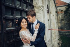 Ευτυχές ζεύγος των newlyweds που φιλά στο ηλιοβασίλεμα με την ΤΣΕ τοίχων κάστρων στοκ φωτογραφία με δικαίωμα ελεύθερης χρήσης Ευτυχές ζεύγος των newlyweds που φιλά στο ηλιοβασίλεμα με την ΤΣΕ τοίχων κάστρων στοκ φωτογραφία με δικαίωμα ελεύθερης χρήσης