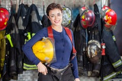 Ευτυχές κράνος εκμετάλλευσης Firewoman στο πυροσβεστικό σταθμό στοκ φωτογραφία με δικαίωμα ελεύθερης χρήσης Ευτυχές κράνος εκμετάλλευσης Firewoman στο πυροσβεστικό σταθμό στοκ φωτογραφία με δικαίωμα ελεύθερης χρήσης