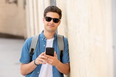 Ευτυχές νέο αρσενικό σπουδαστών στο έξυπνο τηλέφωνό του στη σύγχρονη πόλη στοκ φωτογραφία Ευτυχές νέο αρσενικό σπουδαστών στο έξυπνο τηλέφωνό του στη σύγχρονη πόλη στοκ φωτογραφία