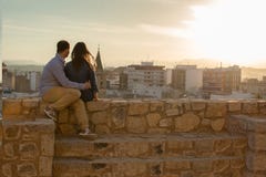 Ευτυχές νέο ζεύγος που εξετάζει τις απόψεις στην πόλη στο ηλιοβασίλεμα στοκ φωτογραφίες με δικαίωμα ελεύθερης χρήσης Ευτυχές νέο ζεύγος που εξετάζει τις απόψεις στην πόλη στο ηλιοβασίλεμα στοκ φωτογραφίες με δικαίωμα ελεύθερης χρήσης