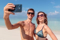 Ευτυχές νέο ζεύγος που παίρνει ένα selfie, σαφές μπλε νερό ως υπόβαθρο αγκάλιασμα στοκ εικόνες Ευτυχές νέο ζεύγος που παίρνει ένα selfie, σαφές μπλε νερό ως υπόβαθρο αγκάλιασμα στοκ εικόνες
