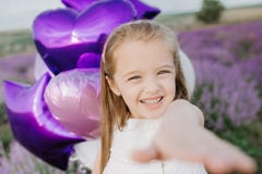Ευτυχές χαριτωμένο μικρό κορίτσι lavender στον τομέα με τα πορφυρά μπαλόνια μαύρη ελευθερία έννοιας που απομονώνεται στοκ εικόνα Ευτυχές χαριτωμένο μικρό κορίτσι lavender στον τομέα με τα πορφυρά μπαλόνια μαύρη ελευθερία έννοιας που απομονώνεται στοκ εικόνα