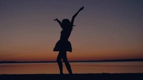 Ευτυχή τρεξίματα γυναικών στο ηλιοβασίλεμα στην παραλία που αυξάνει τα όπλα της επάνω και που περιστρέφει απόθεμα βίντεο Ευτυχή τρεξίματα γυναικών στο ηλιοβασίλεμα στην παραλία που αυξάνει τα όπλα της επάνω και που περιστρέφει απόθεμα βίντεο