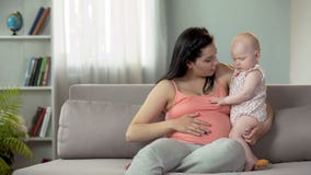 Ευτυχής γυναίκα που αναμένει το δεύτερο μωρό, που λέει πρώτο στο παιδί για τον αδελφό ή την αδελφή στοκ εικόνες Ευτυχής γυναίκα που αναμένει το δεύτερο μωρό, που λέει πρώτο στο παιδί για τον αδελφό ή την αδελφή στοκ εικόνες