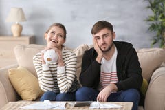 Ευτυχής γυναίκα που κρατά τη piggy τράπεζα και το λυπημένο άνδρα Στοκ φωτογραφία με δικαίωμα ελεύθερης χρήσης Ευτυχής γυναίκα που κρατά τη piggy τράπεζα και το λυπημένο άνδρα Στοκ φωτογραφία με δικαίωμα ελεύθερης χρήσης