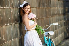 Ευτυχής εκμετάλλευση γυναικών peonies που κλίνει ενάντια στον τοίχο και το χαμόγελο στοκ φωτογραφίες Ευτυχής εκμετάλλευση γυναικών peonies που κλίνει ενάντια στον τοίχο και το χαμόγελο στοκ φωτογραφίες