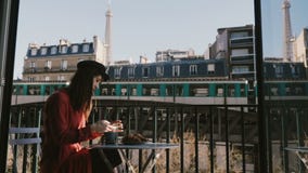 Ευτυχής ελκυστική χαλαρωμένη επιχειρηματίας που απολαμβάνει το πρόγευμα καφέ, που χρησιμοποιεί το smartphone στον καφέ του Παρισι φιλμ μικρού μήκους Ευτυχής ελκυστική χαλαρωμένη επιχειρηματίας που απολαμβάνει το πρόγευμα καφέ, που χρησιμοποιεί το smartphone στον καφέ του Παρισι φιλμ μικρού μήκους