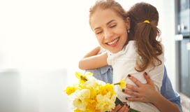 Ευτυχής ημέρα μητέρων ` s! η κόρη παιδιών δίνει στη μητέρα μια ανθοδέσμη του φ Ευτυχής ημέρα μητέρων ` s! η κόρη παιδιών δίνει στη μητέρα μια ανθοδέσμη του φ