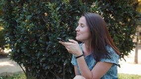 Ευτυχής θερινή συνεδρίαση brunette γυναικών νέων κοριτσιών υπαίθρια στο πάρκο, που χρησιμοποιεί το κινητό τηλέφωνο με τον ήχο AI απόθεμα βίντεο Ευτυχής θερινή συνεδρίαση brunette γυναικών νέων κοριτσιών υπαίθρια στο πάρκο, που χρησιμοποιεί το κινητό τηλέφωνο με τον ήχο AI απόθεμα βίντεο