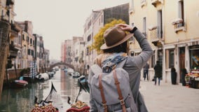 Ευτυχής νέος μοντέρνος ευρωπαϊκός τουρίστας γυναικών στην απόλαυση καπέλων που κοιτάζει γύρω από τη στάση από τα διάσημα κανάλια φιλμ μικρού μήκους Ευτυχής νέος μοντέρνος ευρωπαϊκός τουρίστας γυναικών στην απόλαυση καπέλων που κοιτάζει γύρω από τη στάση από τα διάσημα κανάλια φιλμ μικρού μήκους
