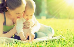 Ευτυχής οικογένεια. Mom και μωρό σε ένα λιβάδι το καλοκαίρι στο πάρκο Ευτυχής οικογένεια. Mom και μωρό σε ένα λιβάδι το καλοκαίρι στο πάρκο