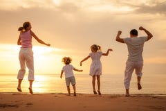 Ευτυχής οικογένεια που πηδά στην παραλία στοκ εικόνα Ευτυχής οικογένεια που πηδά στην παραλία στοκ εικόνα