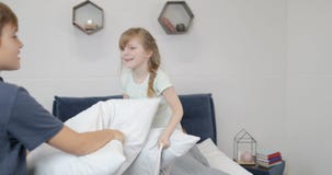 Ευτυχής οικογένεια στην κρεβατοκάμαρα το πρωί, δύο παιδιά που παλεύει τα μαξιλάρια πέρα από τους ευτυχείς χαμογελώντας γονείς που φιλμ μικρού μήκους Ευτυχής οικογένεια στην κρεβατοκάμαρα το πρωί, δύο παιδιά που παλεύει τα μαξιλάρια πέρα από τους ευτυχείς χαμογελώντας γονείς που φιλμ μικρού μήκους
