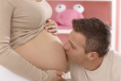 Ευτυχής πατέρας που φιλά την έγκυο κοιλιά στοκ φωτογραφίες Ευτυχής πατέρας που φιλά την έγκυο κοιλιά στοκ φωτογραφίες