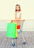 Ευτυχής συνεδρίαση παιδιών μικρών κοριτσιών χαμόγελου σε ένα κάρρο καροτσακιών στοκ εικόνες Ευτυχής συνεδρίαση παιδιών μικρών κοριτσιών χαμόγελου σε ένα κάρρο καροτσακιών στοκ εικόνες