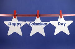 Ευτυχής χαιρετισμός μηνυμάτων ημέρας του Columbus που γράφεται στις άσπρες κάρτες αστεριών που κρεμούν από την κόκκινους κορδέλλα Στοκ Φωτογραφία Ευτυχής χαιρετισμός μηνυμάτων ημέρας του Columbus που γράφεται στις άσπρες κάρτες αστεριών που κρεμούν από την κόκκινους κορδέλλα Στοκ Φωτογραφία