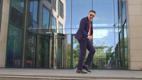 Ευτυχής χορός επιχειρηματιών κοντά στο κτίριο γραφείων απόθεμα βίντεο Ευτυχής χορός επιχειρηματιών κοντά στο κτίριο γραφείων απόθεμα βίντεο