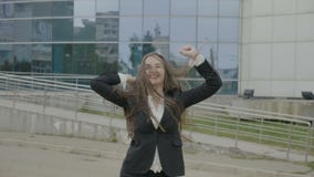 Ευτυχής όμορφη νέα επιχειρηματίας που φορά την εξάρτηση γραφείων που χορεύει χαρωπά στη φύση μπροστά από την εταιρία - απόθεμα βίντεο Ευτυχής όμορφη νέα επιχειρηματίας που φορά την εξάρτηση γραφείων που χορεύει χαρωπά στη φύση μπροστά από την εταιρία - απόθεμα βίντεο