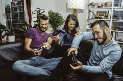 Ευτυχείς συγκινημένοι φίλοι που παίζουν τα τηλεοπτικά παιχνίδια στο σπίτι μαζί και που έχουν τη διασκέδαση στοκ φωτογραφίες με δικαίωμα ελεύθερης χρήσης Ευτυχείς συγκινημένοι φίλοι που παίζουν τα τηλεοπτικά παιχνίδια στο σπίτι μαζί και που έχουν τη διασκέδαση στοκ φωτογραφίες με δικαίωμα ελεύθερης χρήσης