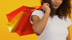 Ευτυχείς τσάντες αγορών εκμετάλλευσης μαύρων γυναικών στο κίτρινο υπόβαθρο, πλάτη μετρητών, μόδα απόθεμα βίντεο Ευτυχείς τσάντες αγορών εκμετάλλευσης μαύρων γυναικών στο κίτρινο υπόβαθρο, πλάτη μετρητών, μόδα απόθεμα βίντεο