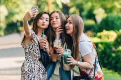 Ευτυχείς φίλοι στο πάρκο μια ηλιόλουστη ημέρα Το πορτρέτο θερινού τρόπου ζωής τριών πολυφυλετικών γυναικών απολαμβάνει τη συμπαθη στοκ εικόνα Ευτυχείς φίλοι στο πάρκο μια ηλιόλουστη ημέρα Το πορτρέτο θερινού τρόπου ζωής τριών πολυφυλετικών γυναικών απολαμβάνει τη συμπαθη στοκ εικόνα
