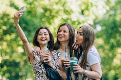 Ευτυχείς φίλοι στο πάρκο μια ηλιόλουστη ημέρα Το πορτρέτο θερινού τρόπου ζωής τριών πολυφυλετικών γυναικών απολαμβάνει τη συμπαθη στοκ φωτογραφία Ευτυχείς φίλοι στο πάρκο μια ηλιόλουστη ημέρα Το πορτρέτο θερινού τρόπου ζωής τριών πολυφυλετικών γυναικών απολαμβάνει τη συμπαθη στοκ φωτογραφία