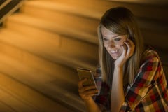 Ευχαριστημένη νέα γυναίκα που διαβάζει τα sms στο κινητό τηλέφωνό της που χαμογελά με τον ενθουσιασμό στις καλές ειδήσεις όπως στ στοκ φωτογραφίες Ευχαριστημένη νέα γυναίκα που διαβάζει τα sms στο κινητό τηλέφωνό της που χαμογελά με τον ενθουσιασμό στις καλές ειδήσεις όπως στ στοκ φωτογραφίες