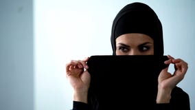 Εύθυμη αραβική γυναίκα που καλύπτει το πρόσωπο από το hijab και που χαμογ στοκ φωτογραφία με δικαίωμα ελεύθερης χρήσης Εύθυμη αραβική γυναίκα που καλύπτει το πρόσωπο από το hijab και που χαμογ στοκ φωτογραφία με δικαίωμα ελεύθερης χρήσης