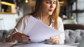 Εύθυμη νέα γυναίκα που ακούει τη μουσική με τα ακουστικά και που χρησιμοποιεί το φορητό προσωπικό υπολογιστή απόθεμα βίντεο Εύθυμη νέα γυναίκα που ακούει τη μουσική με τα ακουστικά και που χρησιμοποιεί το φορητό προσωπικό υπολογιστή απόθεμα βίντεο