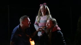 Εύθυμη οικογένεια που τρώει ψημένο marshmallow απόθεμα βίντεο Εύθυμη οικογένεια που τρώει ψημένο marshmallow απόθεμα βίντεο