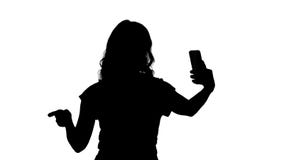 Εύθυμο θηλυκό βίντεο καταγραφής blogger σκιαγραφιών στην μπροστινή κάμερα του σύγχρονου τηλεφώνου περπατώντας απόθεμα βίντεο Εύθυμο θηλυκό βίντεο καταγραφής blogger σκιαγραφιών στην μπροστινή κάμερα του σύγχρονου τηλεφώνου περπατώντας απόθεμα βίντεο