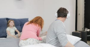 Εύθυμος πατέρας που ακούει τη μουσική που χρησιμοποιεί τα ακουστικά πέρα από τη μητέρα που ηρεμεί το λυπημένο γιο στην οικογένεια φιλμ μικρού μήκους Εύθυμος πατέρας που ακούει τη μουσική που χρησιμοποιεί τα ακουστικά πέρα από τη μητέρα που ηρεμεί το λυπημένο γιο στην οικογένεια φιλμ μικρού μήκους