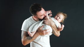 Εύθυμος πατέρας που φέρνει το χαμογελώντας παιδί νηπίων του στο λαιμό πέρα από το μπλε υπόβαθρο φιλμ μικρού μήκους Εύθυμος πατέρας που φέρνει το χαμογελώντας παιδί νηπίων του στο λαιμό πέρα από το μπλε υπόβαθρο φιλμ μικρού μήκους