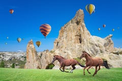 Ζεστού αέρα και δύο άλογα που τρέχουν σε Cappadocia, Τουρκία στοκ εικόνα Ζεστού αέρα και δύο άλογα που τρέχουν σε Cappadocia, Τουρκία στοκ εικόνα