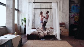 Ζεύγος Multiethnic στις πυτζάμες που έχουν τη διασκέδαση από κοινού Αφρικανικός άνδρας και Ευρωπαία γυναίκα που χορεύουν, πηδώντα Ζεύγος Multiethnic στις πυτζάμες που έχουν τη διασκέδαση από κοινού Αφρικανικός άνδρας και Ευρωπαία γυναίκα που χορεύουν, πηδώντα
