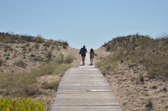 Ζεύγος που περπατά στο θαλάσσιο περίπατο προς την παραλία θάλασσας στοκ φωτογραφίες Ζεύγος που περπατά στο θαλάσσιο περίπατο προς την παραλία θάλασσας στοκ φωτογραφίες