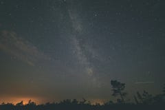 ζωηρόχρωμος γαλακτώδης γαλαξίας τρόπων που βλέπει στο νυχτερινό ουρανό πέρα από τα δέντρα - τρύγος Στοκ Εικόνες ζωηρόχρωμος γαλακτώδης γαλαξίας τρόπων που βλέπει στο νυχτερινό ουρανό πέρα από τα δέντρα - τρύγος Στοκ Εικόνες