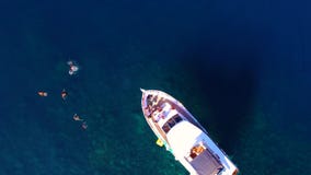 Η άποψη πέρα από το ιδιωτικό γιοτ εν πλω, άνθρωποι λούζει κοντά στο γιοτ απόθεμα βίντεο Η άποψη πέρα από το ιδιωτικό γιοτ εν πλω, άνθρωποι λούζει κοντά στο γιοτ απόθεμα βίντεο
