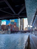 Η άποψη του Σικάγου Riverwalk με τον ατμό που φυσά πέρα από το και ο ποταμός του Σικάγου ως temps βυθίζουν στοκ φωτογραφία Η άποψη του Σικάγου Riverwalk με τον ατμό που φυσά πέρα από το και ο ποταμός του Σικάγου ως temps βυθίζουν στοκ φωτογραφία