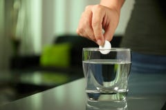 Η άρρωστη γυναίκα βάζει τη ζωηρή ταμπλέτα aspirin στο ποτήρι του νερού στοκ φωτογραφία με δικαίωμα ελεύθερης χρήσης Η άρρωστη γυναίκα βάζει τη ζωηρή ταμπλέτα aspirin στο ποτήρι του νερού στοκ φωτογραφία με δικαίωμα ελεύθερης χρήσης